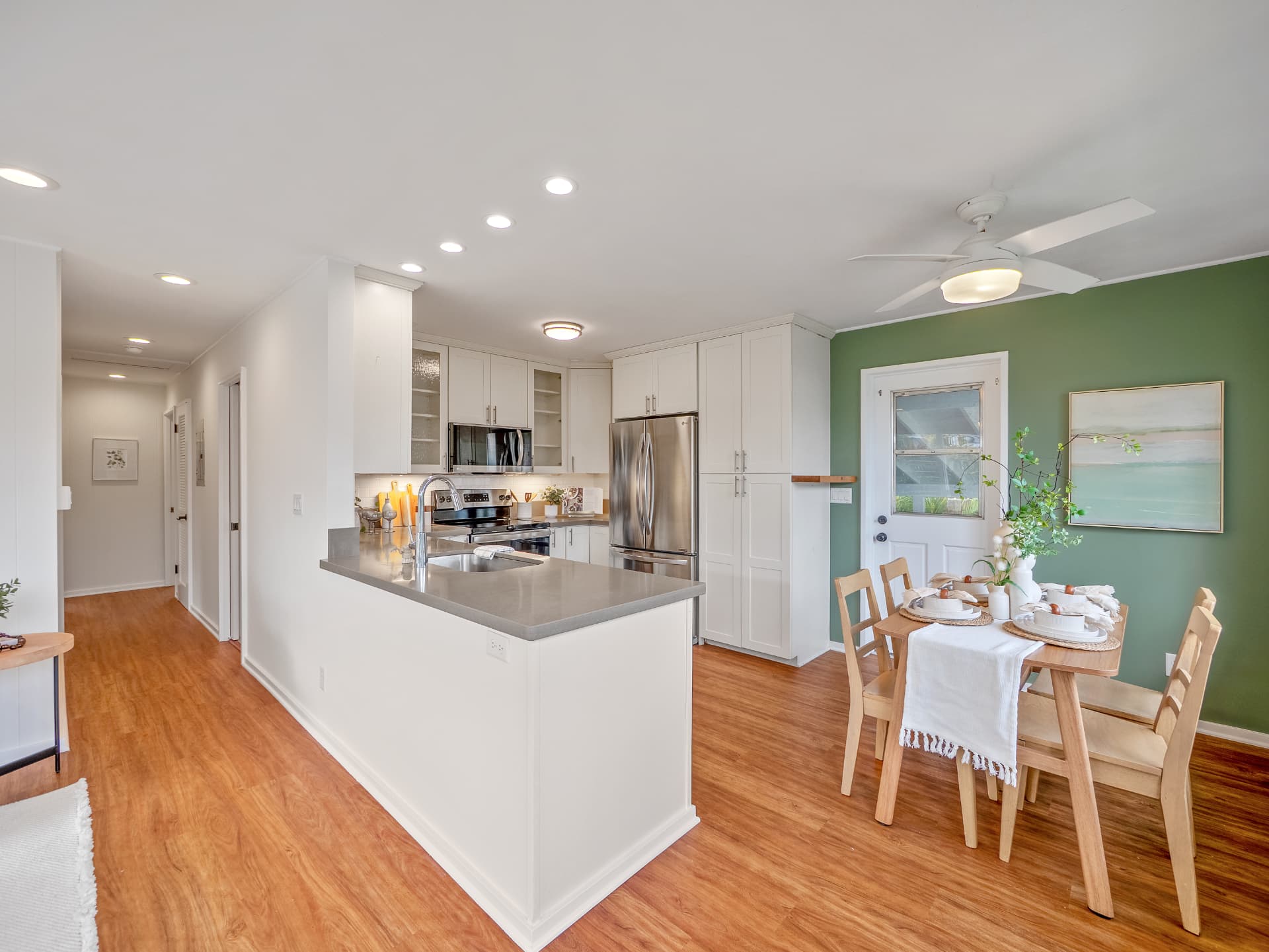 Kitchen peninsula with green accent wall dining nook
