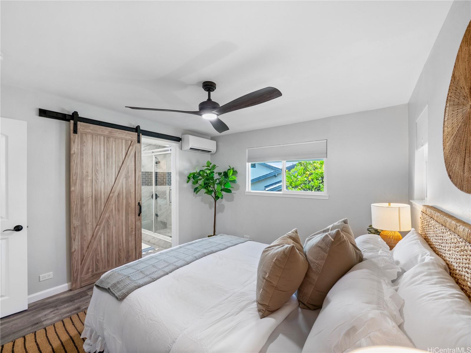 Primary bedroom with barn door to the ensuite shower