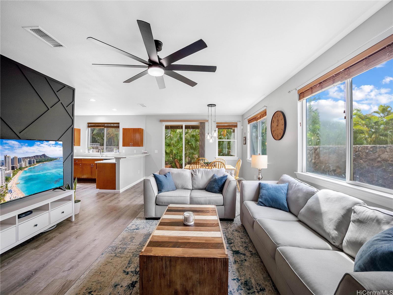 Bright living room with ocean-view TV wall and open kitchen