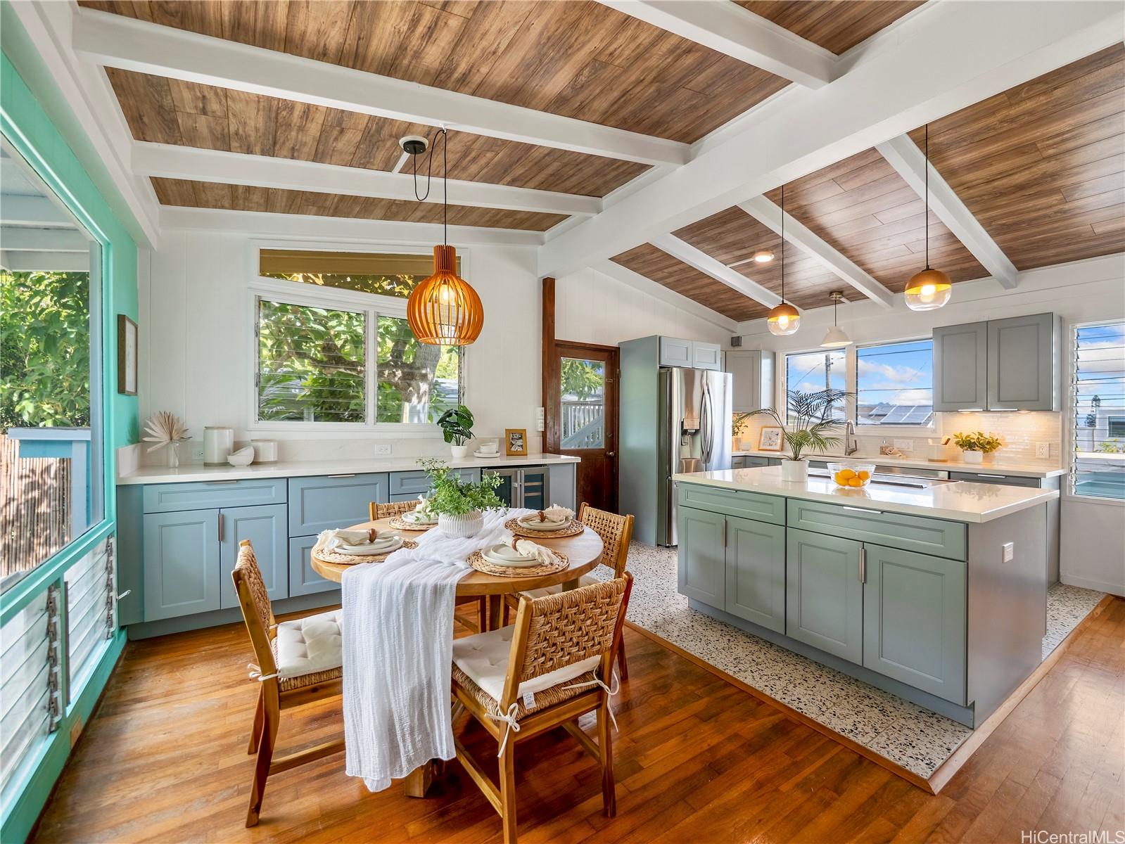 Renovated kitchen and dining with island and wood plank ceiling