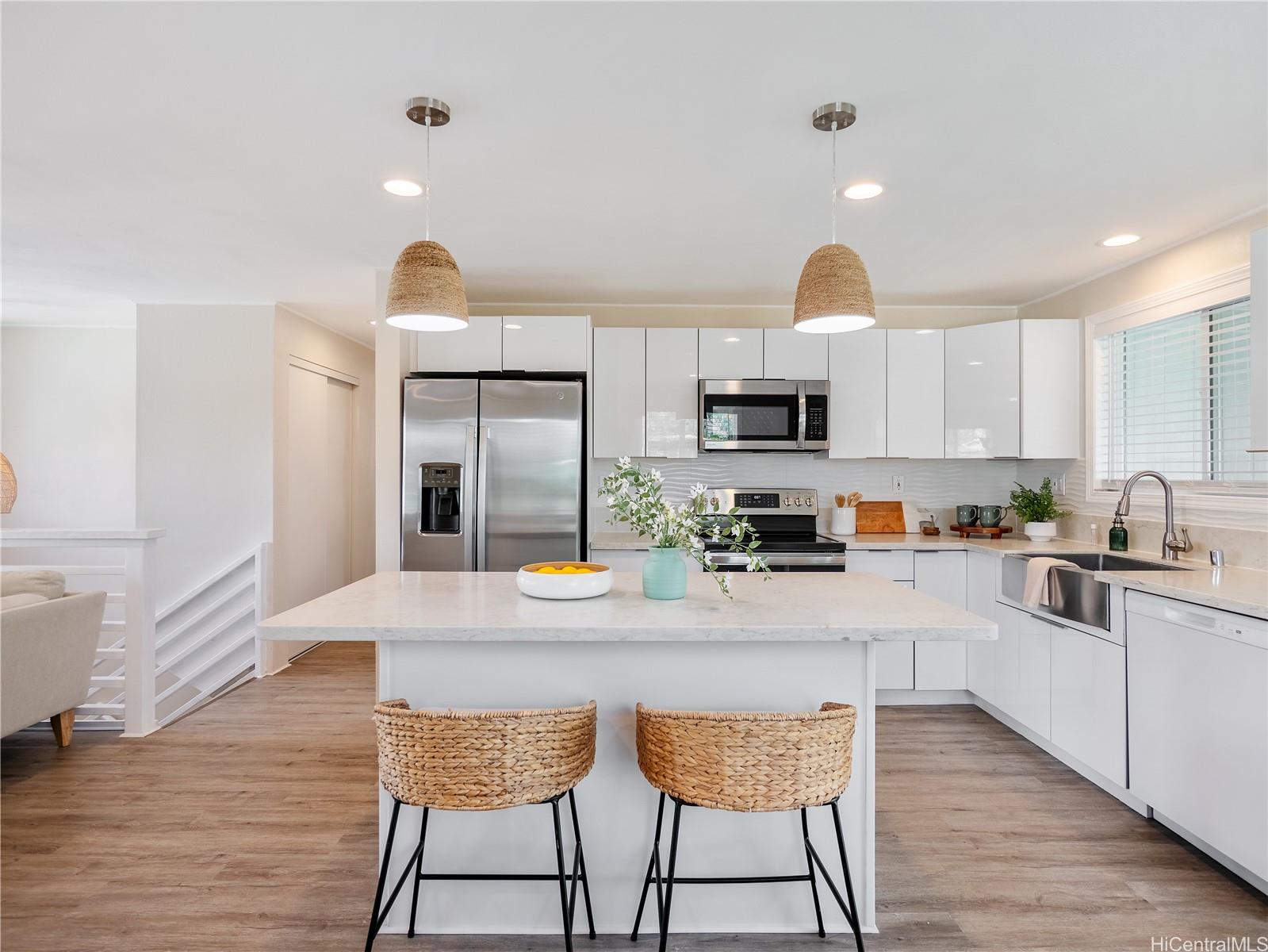 Renovated kitchen with quartz island and stainless appliances